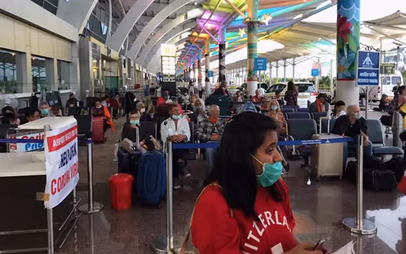 I passeggeri del volo Goa-Zurigo sono in attesa nell'atrio dell'aeroporto di Goa.