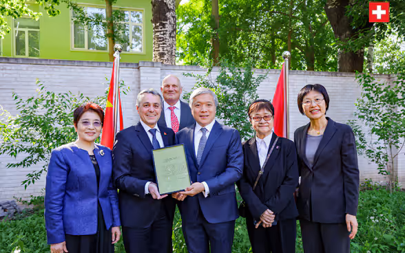 Il consigliere federale Ignazio Cassis, l'ambasciatore svizzero in Cina Jürg Burri e la delegazione cinese posano nel giardino dell'Ambasciata svizzera a Pechino. 