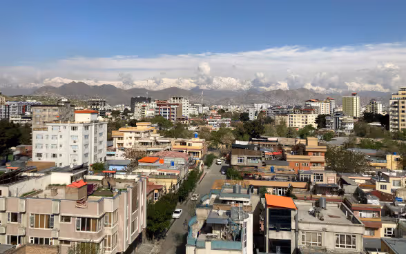 Vista dall’alto su Kabul, con cime innevate sullo sfondo.