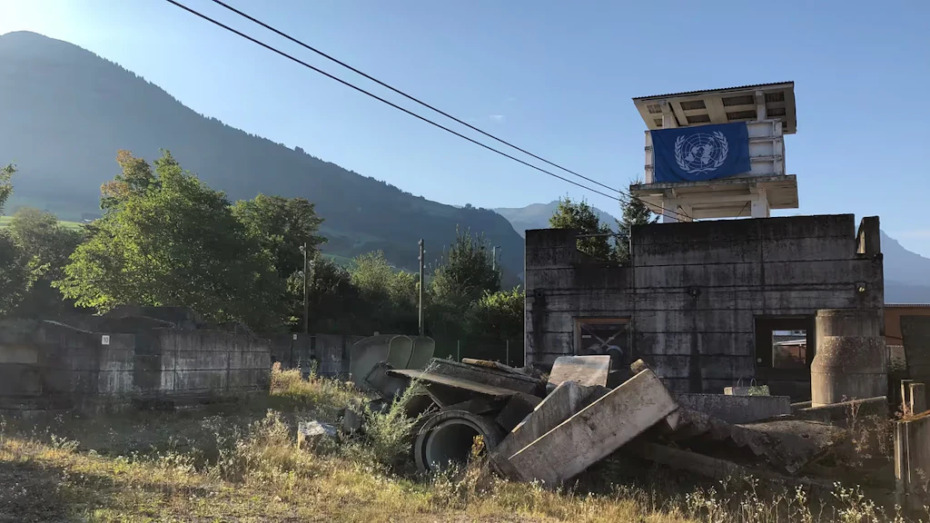 Una torre di legno bianca con la bandiera dell’ONU in un idilliaco paesaggio montano vicino Stans. 