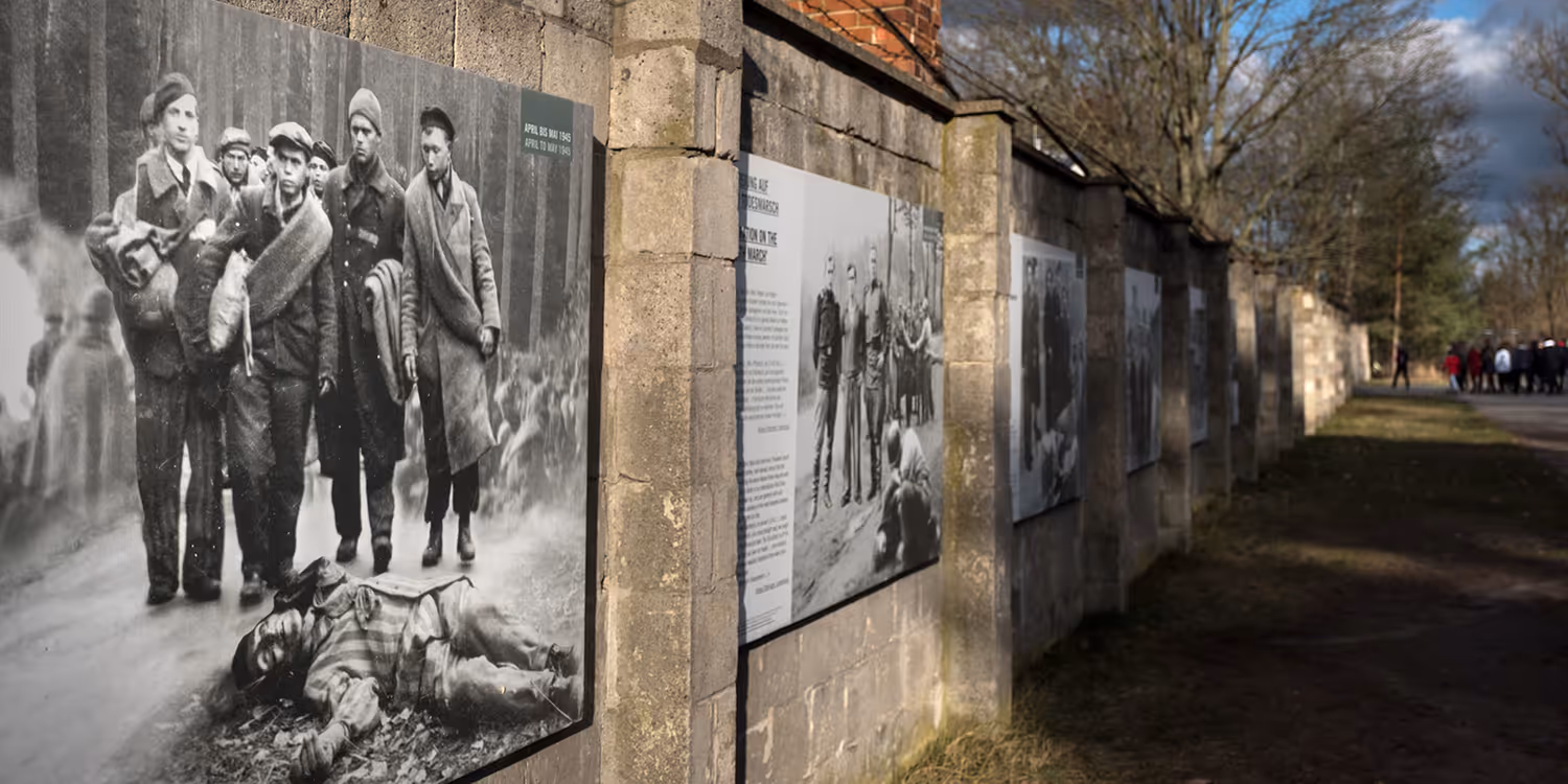 Muro dell’ex campo di concentramento di Sachsenhausen con immagini storiche e pannelli informativi.